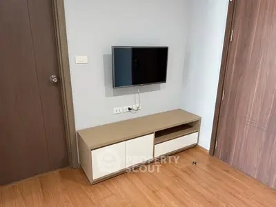 Modern living room with mounted TV and sleek wooden cabinet
