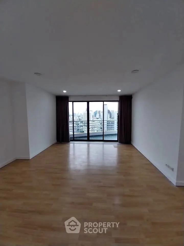 Spacious empty living room with city view through large windows, perfect for customization.