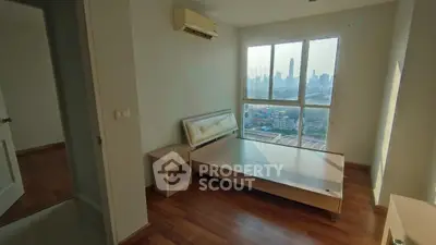 Spacious bedroom with city view, featuring wooden flooring and air conditioning, perfect for urban living.