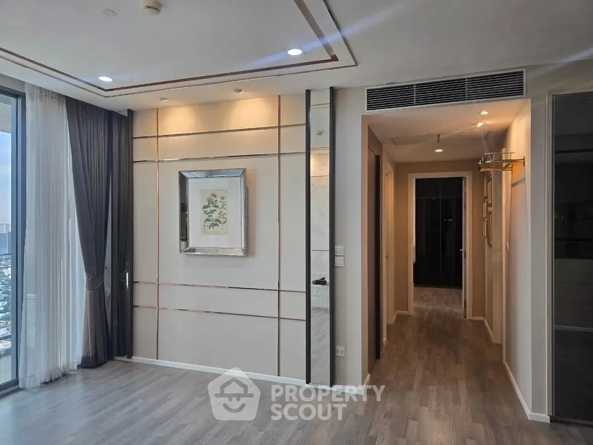 Spacious modern living room with elegant decor and large windows offering natural light.