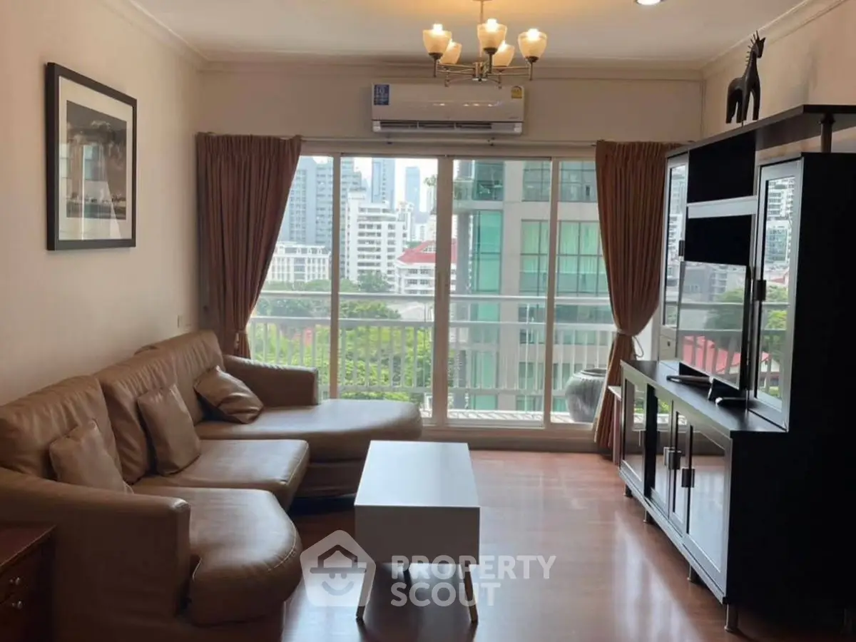 Spacious living room with city view, modern furniture, and natural light.