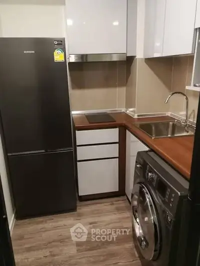 Modern compact kitchen with sleek appliances and wood accents