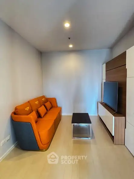 Modern living room with orange sofa and sleek TV unit