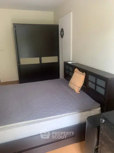 Cozy bedroom with modern dark wood furniture and a comfortable bed.