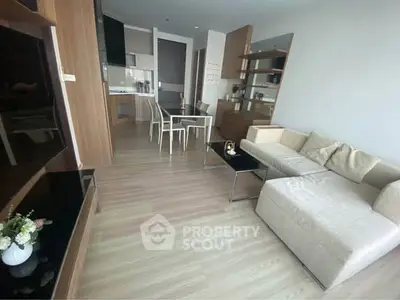Modern living room with open kitchen and stylish furniture in a contemporary apartment.