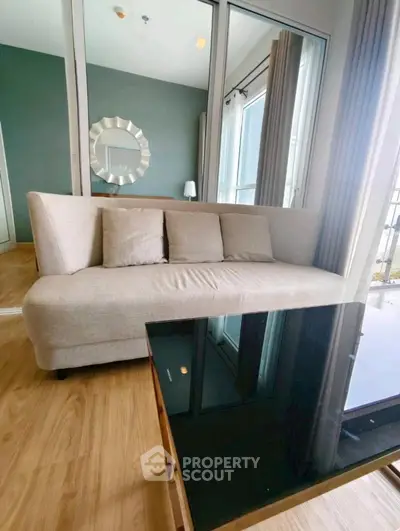 Modern living room with stylish sofa and glass coffee table in a bright apartment.