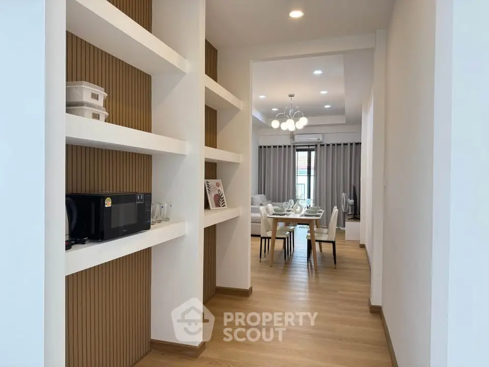 Modern dining area with built-in shelves and elegant lighting, perfect for stylish living.