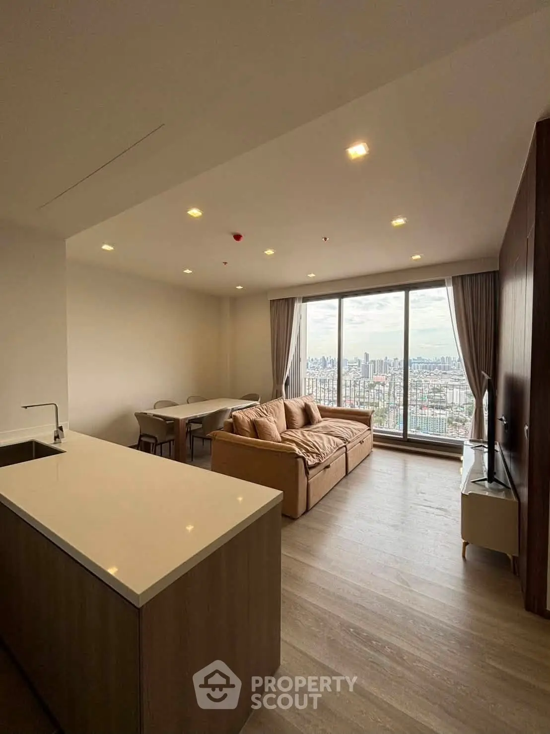 Spacious modern living room with panoramic city view and elegant furnishings.