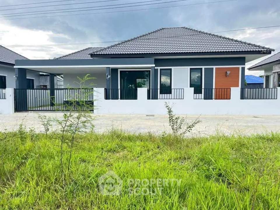 Modern single-story house with sleek design and spacious front yard, perfect for family living.