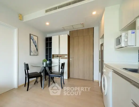 Modern kitchen with dining area, featuring sleek appliances and stylish decor in a contemporary apartment.