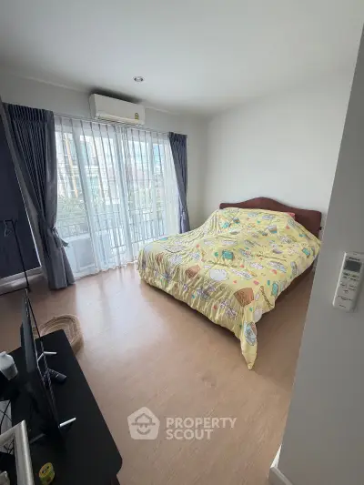 Spacious bedroom with large windows and modern decor in a stylish apartment.