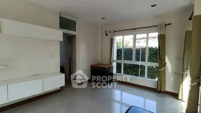 Bright living room with large window and modern furnishings in a stylish home.