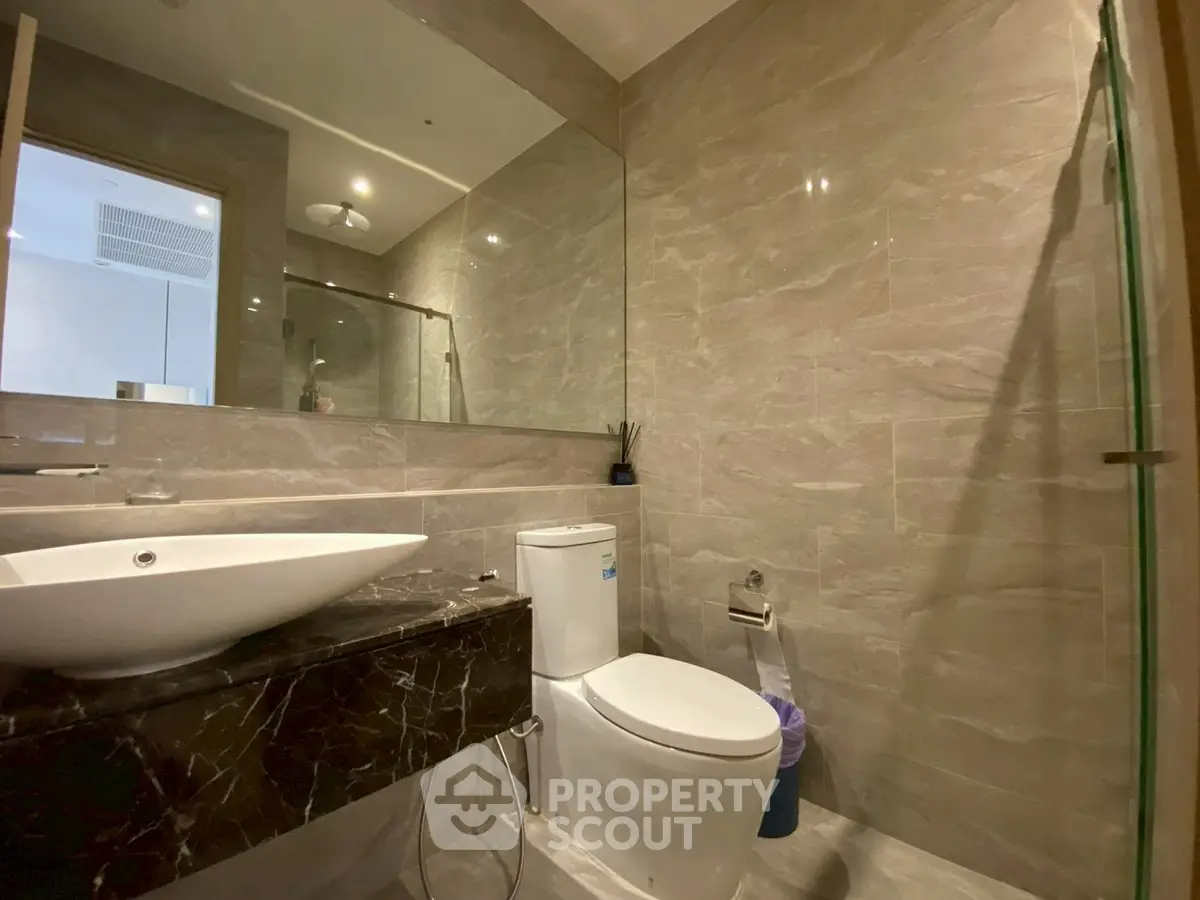 Modern bathroom with elegant marble sink and spacious shower area