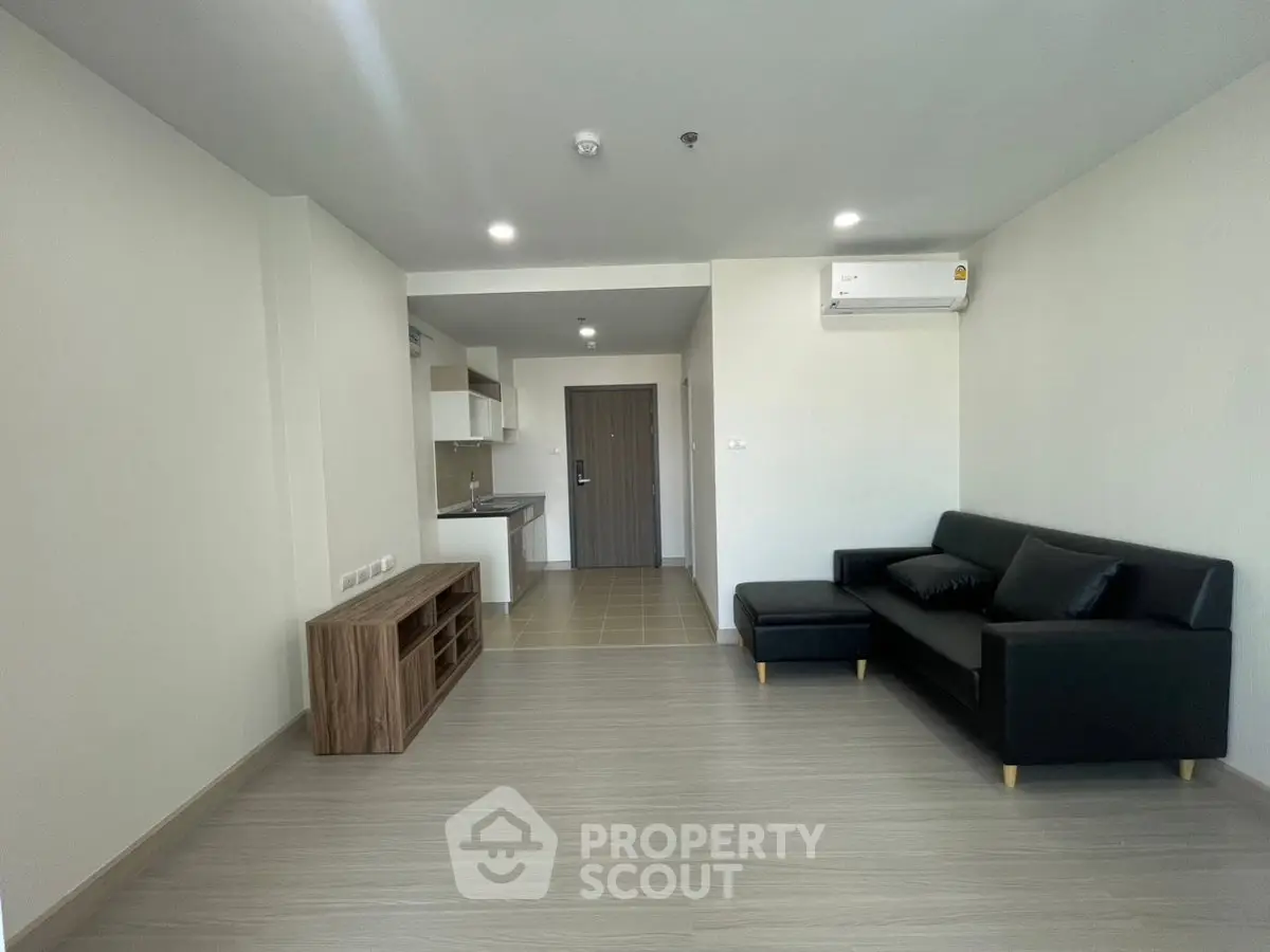 Modern living room with sleek furniture and open kitchen layout in a stylish apartment.
