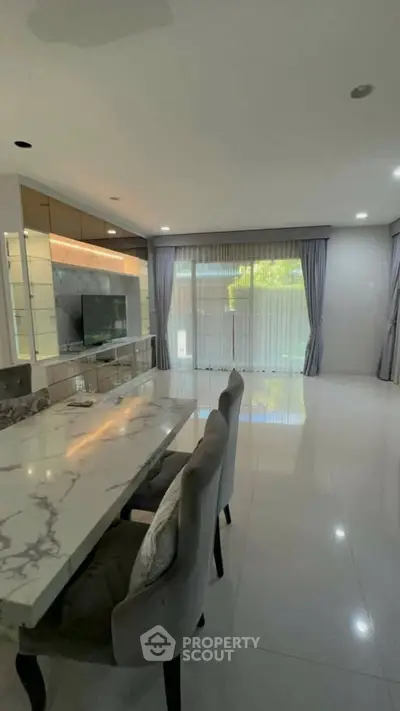 Spacious modern living room with elegant marble dining table and large windows