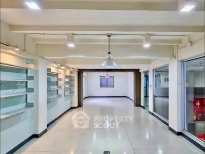 Spacious commercial interior with modern lighting and ample shelving, ideal for retail or office use.