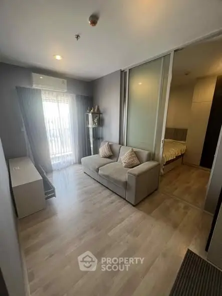 Modern living room with cozy sofa and sliding door leading to bedroom