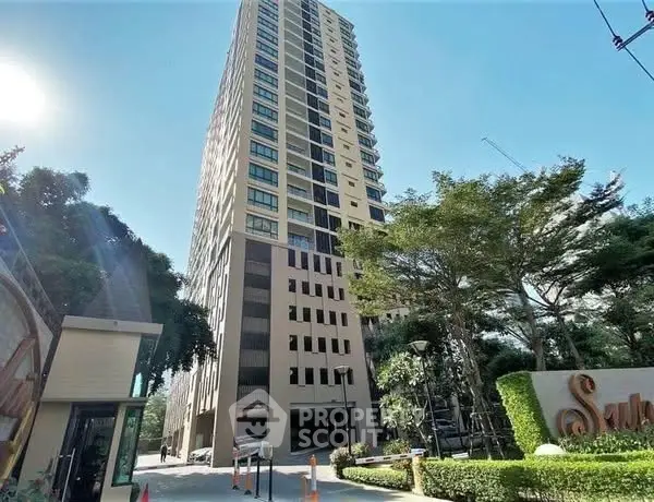 Stunning high-rise building with modern architecture and lush greenery in urban setting.
