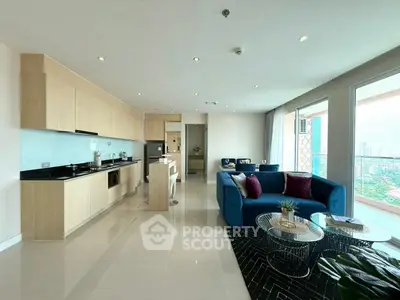 Spacious modern living room with open kitchen and city view, featuring elegant decor and ample natural light.