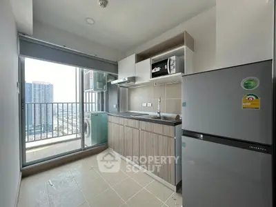 Modern kitchen with balcony view, featuring sleek appliances and ample natural light.