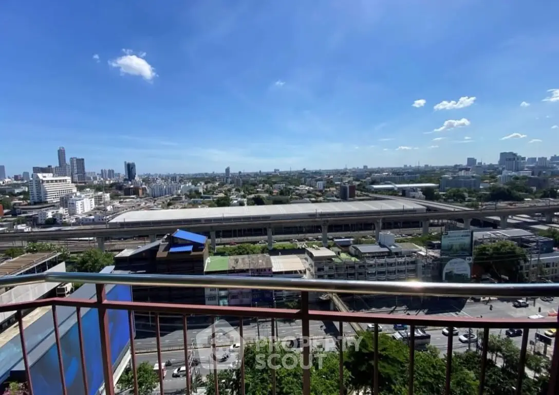 Stunning cityscape view from a high-rise balcony overlooking urban skyline and transit lines.