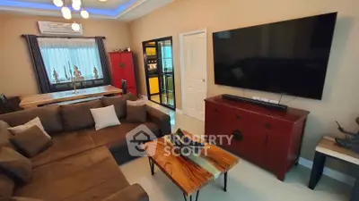 Luxurious living room with modern decor and large flat-screen TV, perfect for relaxation and entertainment.