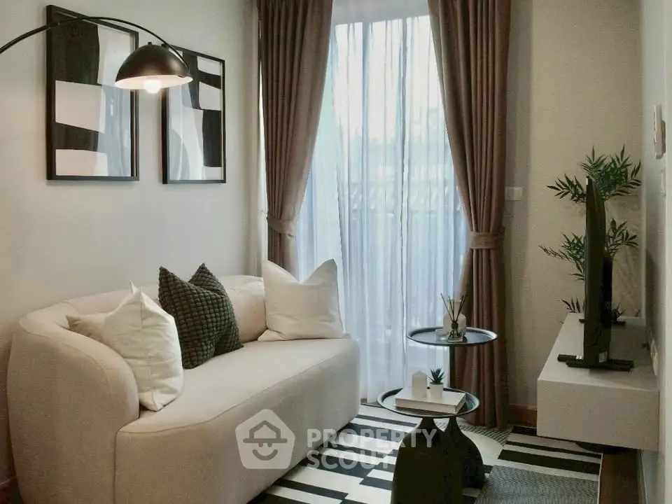 Stylish modern living room with cozy sofa, elegant decor, and natural light through large window.