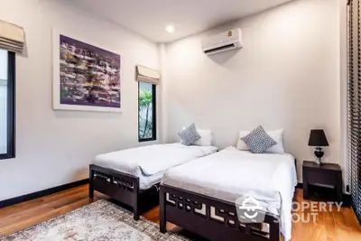 Spacious bedroom with twin beds and modern decor in a stylish home.