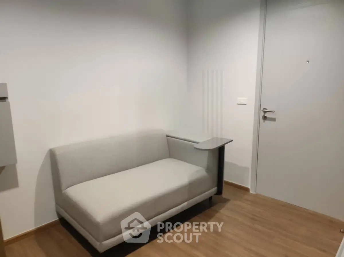 Modern minimalist interior with sleek sofa and wooden flooring, perfect for contemporary living spaces.