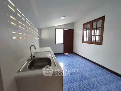Spacious kitchen with blue tiled floor and natural light