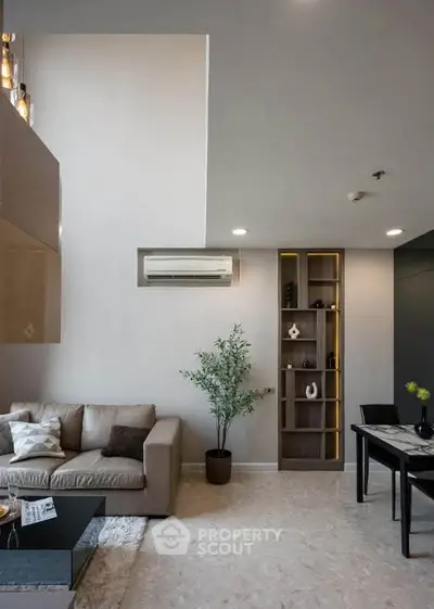 Modern living room with stylish decor and open layout, featuring a cozy sofa and elegant shelving.