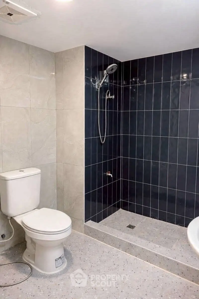 Modern bathroom with sleek shower and tiled walls in a contemporary real estate property.