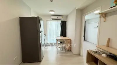 Modern apartment interior with kitchen and dining area, featuring sleek appliances and natural light.
