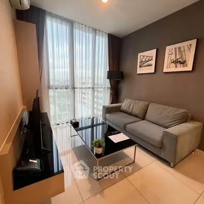 Modern living room with large windows and stylish decor in a high-rise apartment.