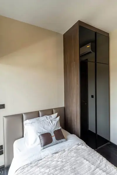 Modern bedroom with sleek design and built-in wardrobe, featuring neutral tones and stylish decor.