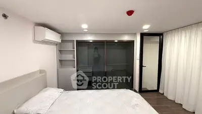 Modern bedroom with sleek design and ample storage in a contemporary apartment.