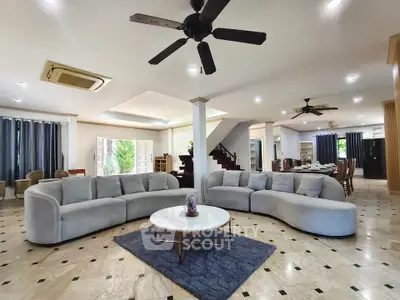 Spacious modern living room with elegant curved sofas and stylish ceiling fans