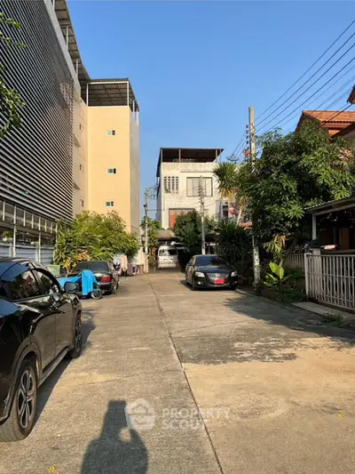 Charming residential street view with modern buildings and lush greenery, perfect for urban living.