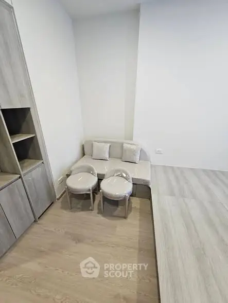 Modern minimalist living space with sleek wooden flooring and compact furniture.