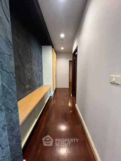 Sleek modern hallway with wooden flooring and built-in storage