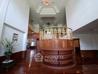 Luxurious two-story living room with elegant wooden flooring and ornate gold railing