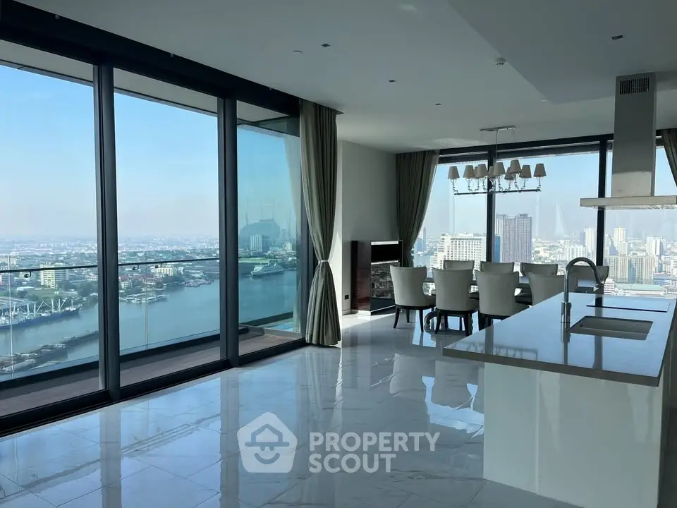 Luxurious open-plan living room with stunning city and river views, featuring modern kitchen and elegant dining area.