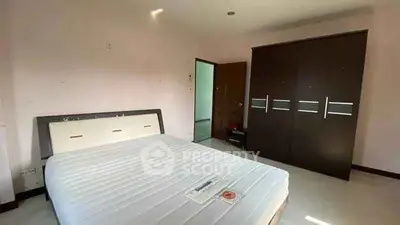 Spacious bedroom with modern wardrobe and comfortable bed in a well-lit interior.