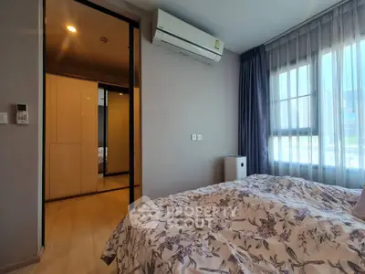 Cozy bedroom with floral bedding and ample natural light, featuring a modern air conditioning unit.