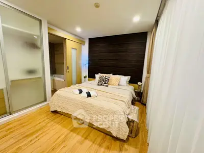 Modern bedroom with cozy decor and wooden flooring in a stylish apartment.