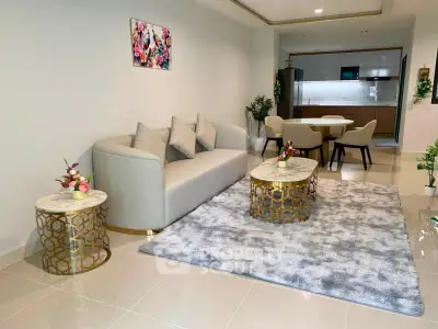Modern living room with elegant decor and open layout leading to a stylish kitchen.
