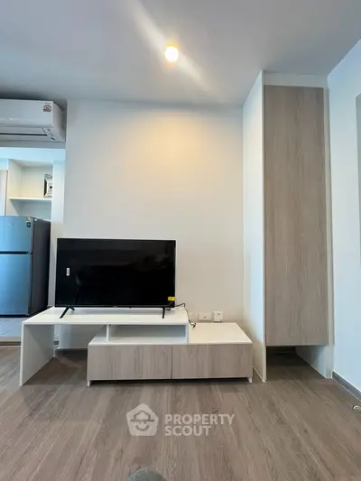 Modern living room with sleek TV stand and air conditioning, featuring minimalist design and wood flooring.