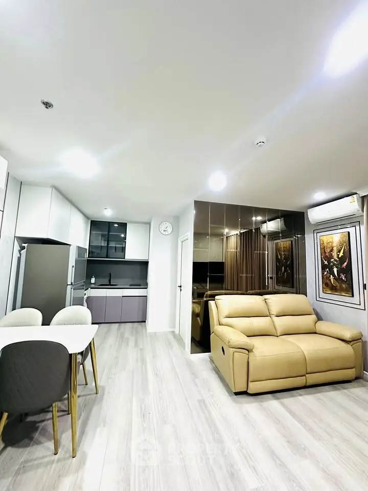 Modern living room with beige sofa and sleek kitchen in open layout