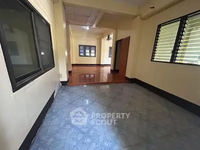 Spacious interior with tiled floors and large windows, perfect for natural light and versatile living space.