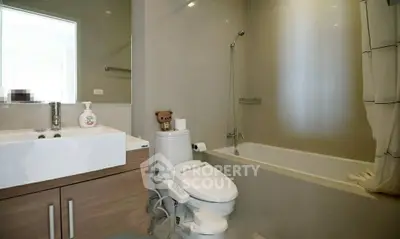 Modern bathroom with sleek fixtures and bathtub in a contemporary home.
